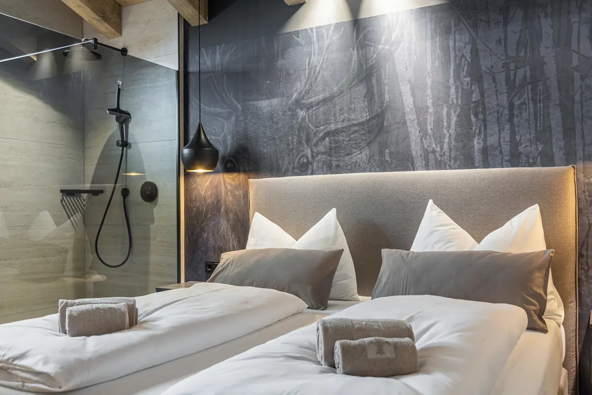 Suite mit Doppelbett vor einer Natursteinwand